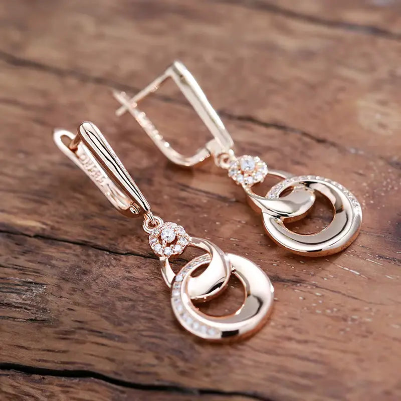 Boucles d'oreilles pendantes anneaux enlacés, bijou en plaqué or rose et en zircons naturels